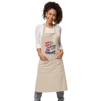 Model with cream color 100% Organic cotton apron with retro flowers design with the phrase "Small Acts Big Impact"